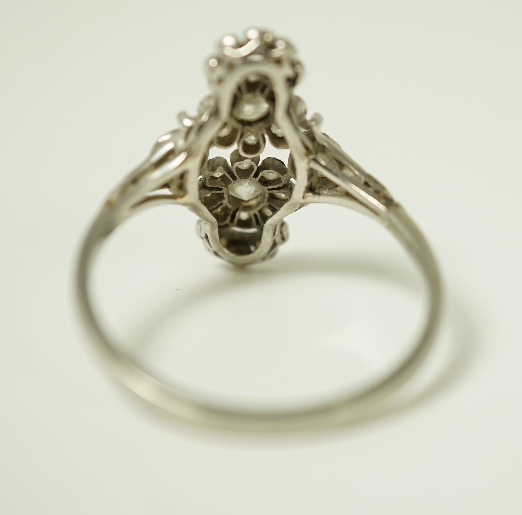 A 1920's platinum and millegrain diamond set flower head cluster upfinger ring